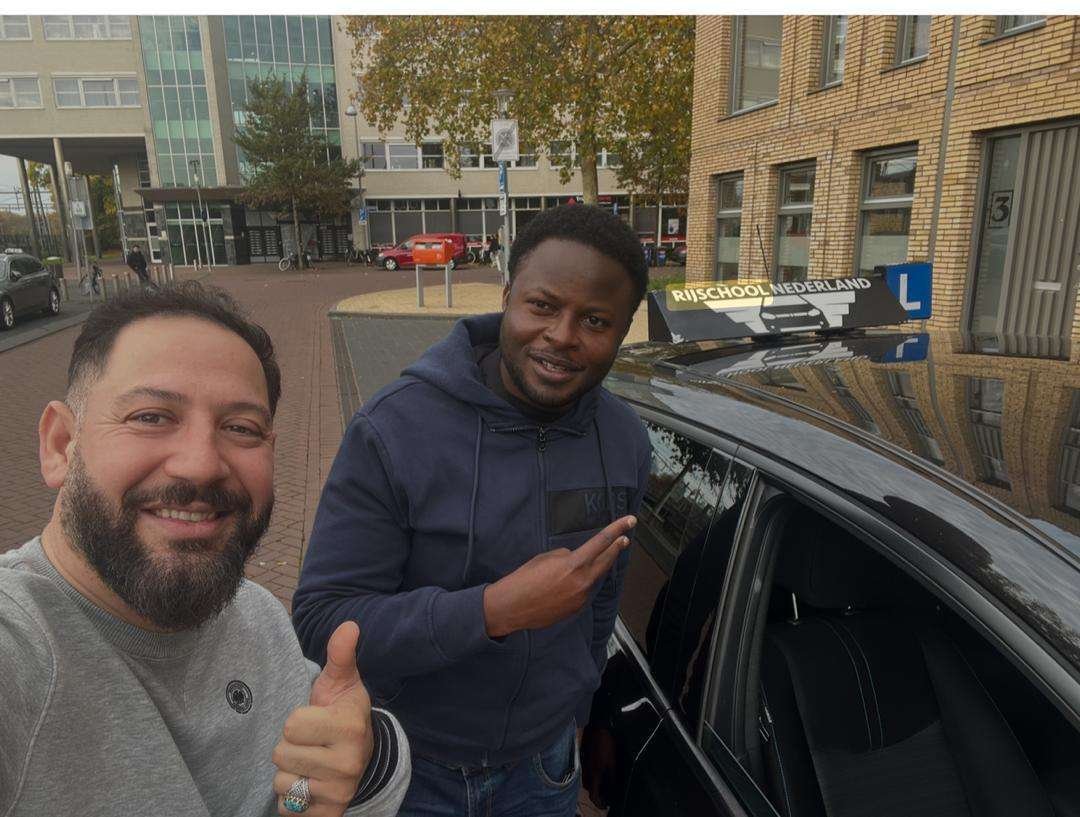 Rijinstructeur met een leerling bij de lesauto