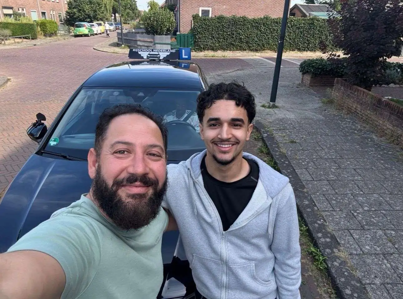 Leerling en instructeur na een geslaagde rijles